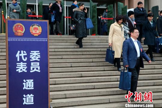 图为会议结束后，政协委员们从委员通道走出会场?！×籂?摄