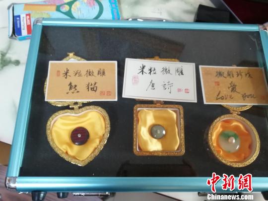 济南微雕非遗传承人王天明将大熊猫、唐诗等微雕在米粒上?！∷镦面?摄