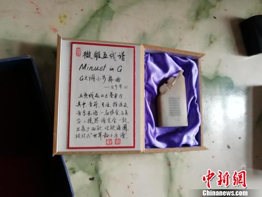 在一块2厘米长，1.3厘米宽的玉石上，王天明雕刻了贝多芬的《G大调小步舞曲》?！∷镦面?摄