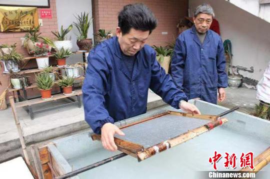 庄富泉正在制作竹纸?！∨硐?摄