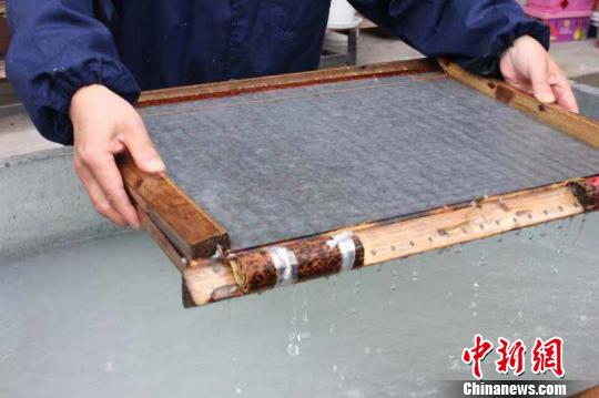 庄富泉正在制作竹纸?！∨硐?摄