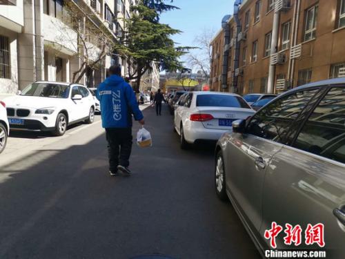 图为饿了么配送员正在送餐。 谢艺观 摄