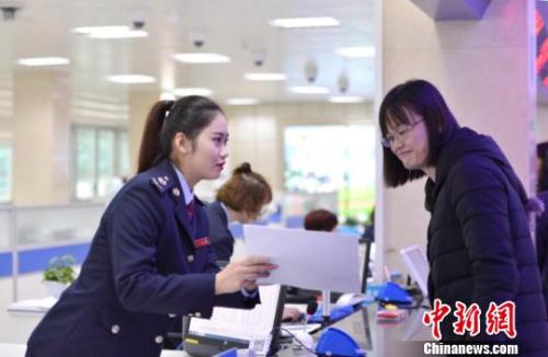 资料图：税务人员为纳税人讲解相关涉税事项。王旺旺 摄