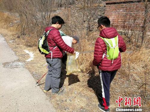 图为活动参与者在拣拾路边的垃圾。招嘉虹/摄 招嘉虹 摄