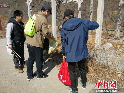 登山队员们一手握夹子、一手拎袋子，开展登山捡拾垃圾活动。招嘉虹/摄 招嘉虹 摄