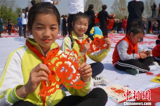 小学生们展示剪纸牡丹。　韩章云 摄