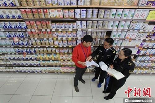 资料图：超市内工作人员在检查奶粉。<a target='_blank' href='http://www.chinanews.com/'>中新社</a>记者 张娅子 摄