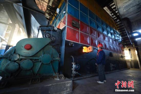 资料图。内蒙古呼和浩特一燃煤锅炉房内，工作人员操作供暖设备。<a target='_blank' href='http://www.chinanews.com/'>中新社</a>发 刘文华 摄