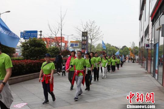 专业教练演示健走的标准姿势及正确的热身方式，并带领参赛人群进行实地健走活动?！〕戮?摄