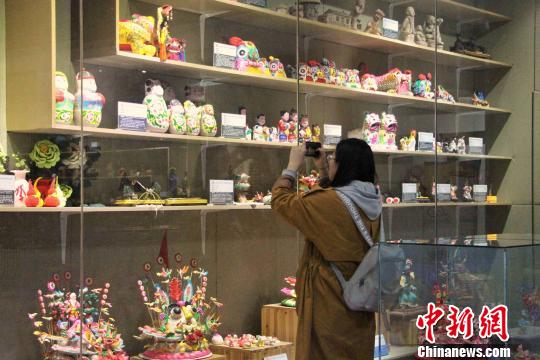 图为观众参观位于山东省文化馆的山东非遗精品展厅?！≌韵?摄