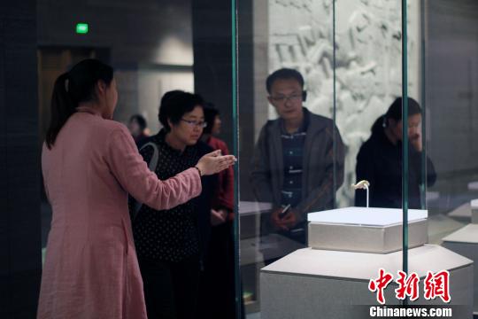 图为，观众在孔子博物馆展品前驻足观赏，仔细聆听讲解员解说?！⊥醴?摄