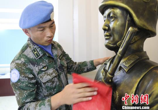 卞龙擦拭申亮亮烈士的雕像?！⊙钤傩?摄