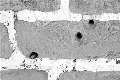 黄楼院长城敌楼上的一块青砖，分布着弹孔
