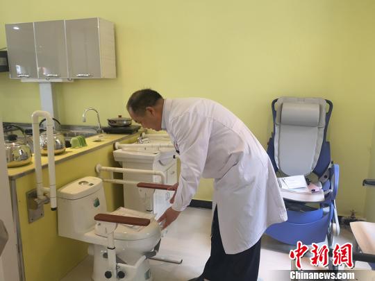 图为甘肃省辅具中心主任王应良进行残障人辅助工具用途的讲解?！「呖档?摄