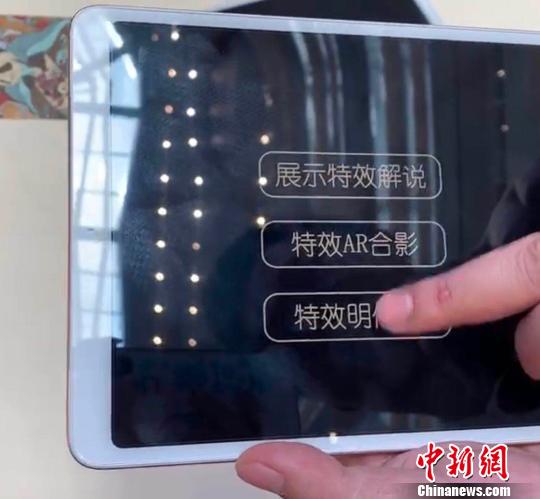 工作人员示范裸眼AR技术?！≈有?摄