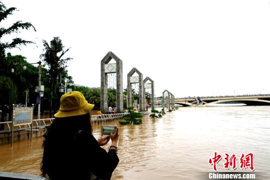图为一民众在桂林解放桥滨江路拍摄洪水?！√泼蜗?摄