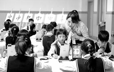 昆明市盘龙小学教师指导学生体验智能书法课。新华社发 点击进入下一页