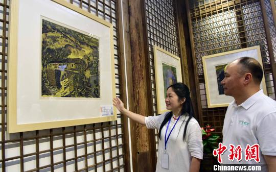 6月12日，松溪版画院院长蔡丽(左)与松溪版画院顾问兰坤发(右)一起欣赏版画作品。　张丽君 摄