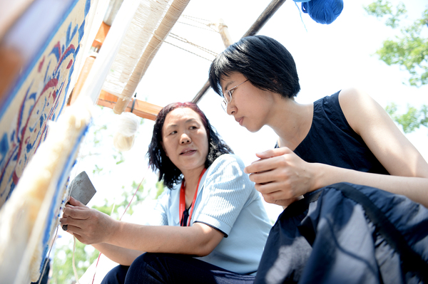 7活动现场，参观者听取牧民讲诉骆驼毛毛毯的纺织技艺