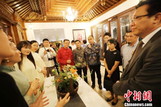 图为当晚在中国驻东盟大使官邸举办的“中国民俗文化之夜”，各国外交官赏花艺?！×钟来?摄