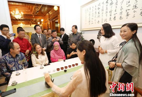 图为当晚在中国驻东盟大使官邸举办的“中国民俗文化之夜”，各国外交官品茶道?！×钟来?摄