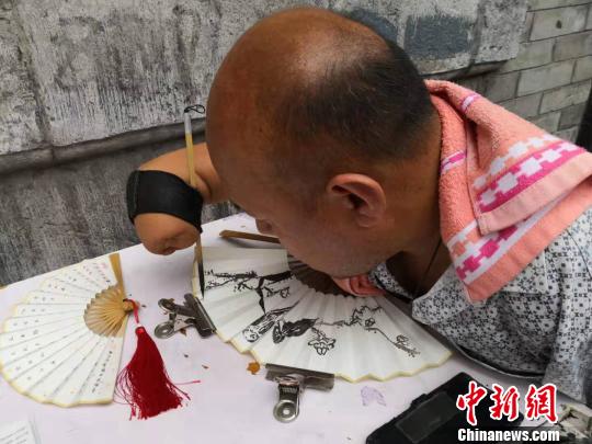 贾维军在扇面上写字?！“⒘漳?摄