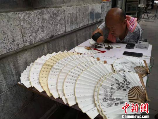 贾维军正在聚精会神地写字。　阿琳娜 摄