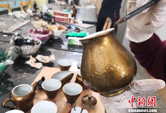 图为学生给茶杯上漆?！×跤裉?摄