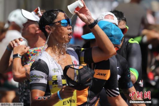 一向比较凉爽的德国也没有躲过这股热浪，多地都经历了历史同期以来的最高温度。图为在法兰克福举行的铁人三项比赛中，运动员用饮用水“冲凉”。