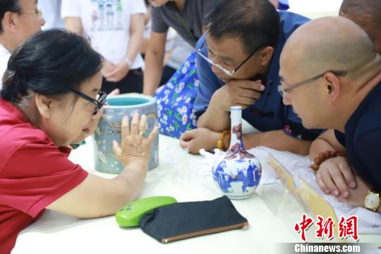 北京市文物鉴定委员会秘书长张如兰为市民鉴定收藏品。供图