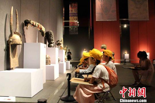 图为小学生们拿着画板在展览现场临摹艺术品?！≌韵?摄