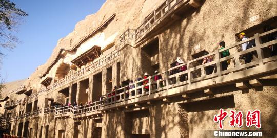 图为游客参观敦煌莫高窟?！∥航ň?摄