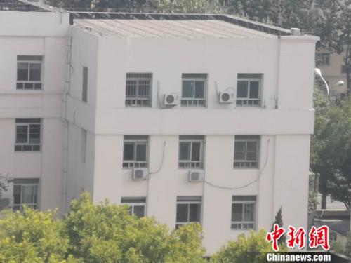 图为居民楼外的空调外机。 谢艺观 摄