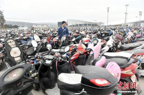 12月14日，福州仓山南二环附近的临时停车场停放超过2.2万辆无牌、超标电动车，场面震撼。福州市交警一个多月来共查处电动车各类交通违法14万多起，暂扣无牌、超标电动车2.2万多辆。图为市民凭有效证件及购车发票领回被扣车辆。<a target='_blank' href='http://www.chinanews.com/'>中新社</a>记者 吕明 摄