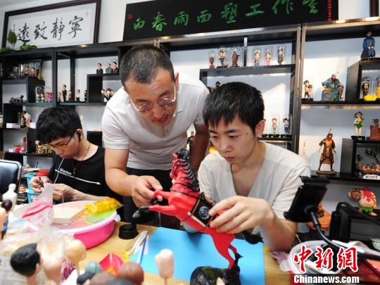 白春雨正在指导徒弟制作面塑 刘栋 摄