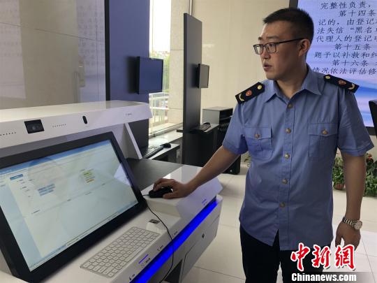 图为工作人员展示新的系统程序?！⊙钜?摄