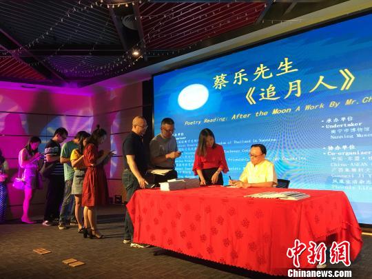 图为泰王国驻南宁总领事馆总领事蔡乐·蓬蒂窝拉卫为诗集《追月人》读者签字留念?！　〕虑锵?摄