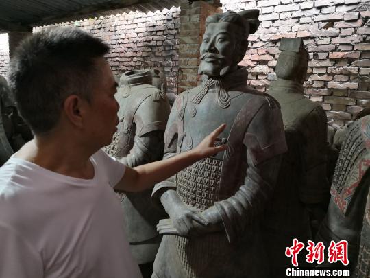 图为马石凹介绍兵马俑仿制品?！〉程镆?摄