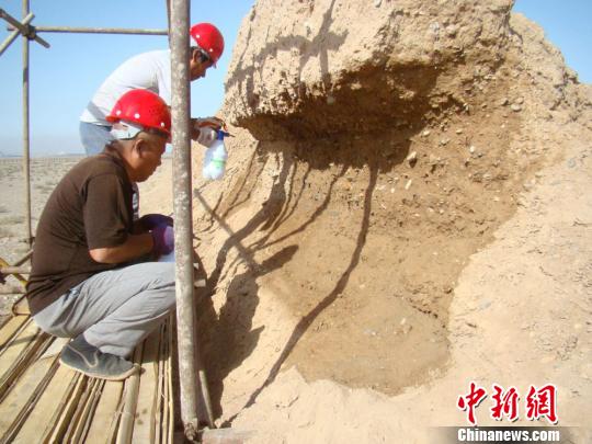 图为工作人员正在给长城“治病”，实施?；の?。(资料图) 钟欣 摄