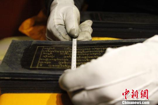 图为罗布林卡管理处工作人员测量古籍尺寸?！≌岳?摄