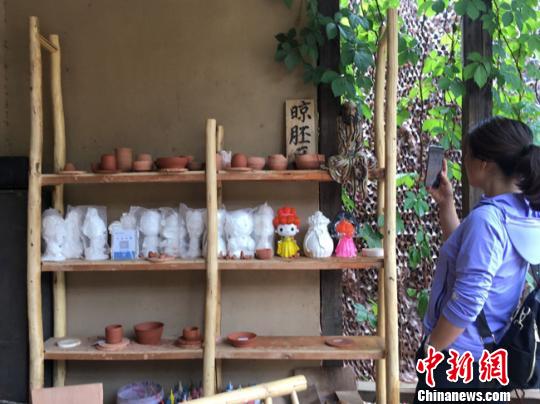 图为月牙泉小镇“敦煌彩陶”门口晾胚区吸引当地人拍照留念?！≌沛?摄