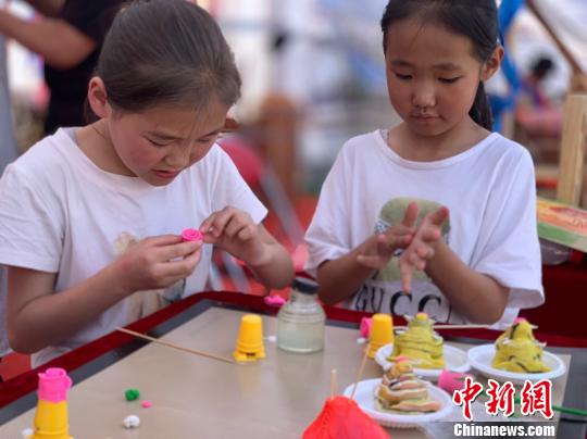 图为两个小女孩正在捏米塑。　孙睿 摄