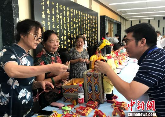 图为“秦观故里”高邮三垛七夕习俗“巧娘娘送巧”——心灵手巧的妇女将自己一针一线手工制作的虎鞋送给孩子?！〈藜衙?摄