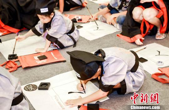 小朋友开笔书写“人”字。供图