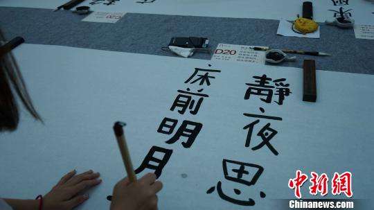 图为中日韩青少年正在用毛笔书写唐诗?！〉程镆?摄