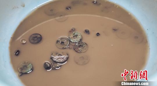 工作人员对古钱币进行清理?！⊙盍⒊?摄