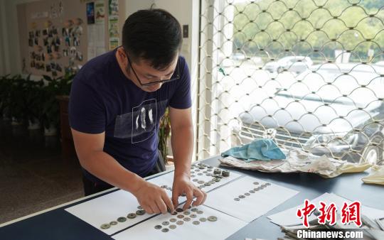 工作人员在研究古钱币“身份”?！⊙盍⒊?摄
