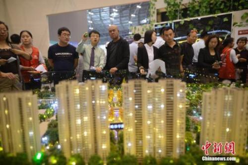 资料图：售楼员为民众推荐商品房户型。 韦亮 摄