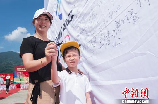 图为坦洋村民在助威冬奥的条幅上签字?！∠牟ü?摄