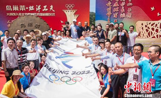 图为嘉宾在助威冬奥的条幅前合影留念?！∠牟ü?摄